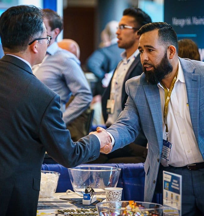 Men shaking hands in front of a CMA Shipping
